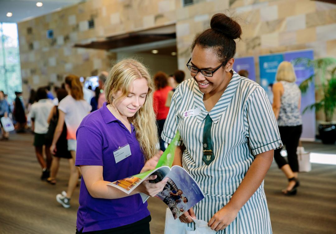 Two school students looking at brochure