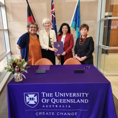 UQ VC, FNUniv President, UQ DVCIE, and UQ Professor of Indigenous Education pose holding signed MoU