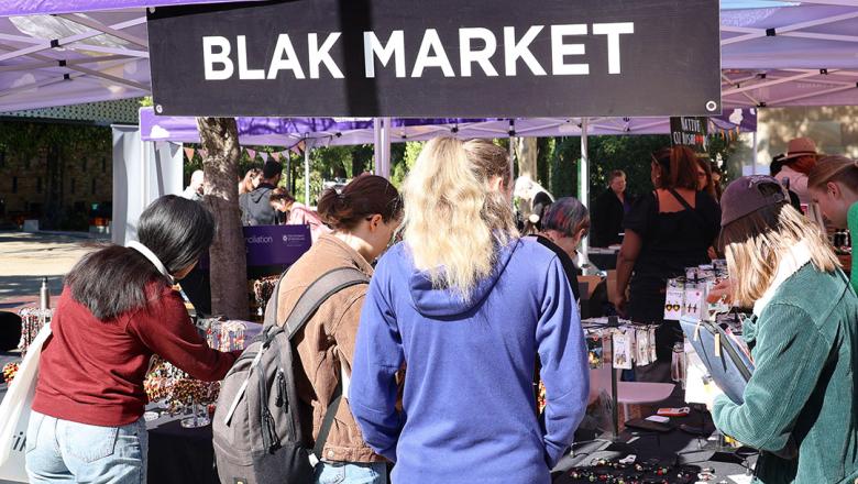 People looking at a stall in the UQ NAIDOC Week Blak Market