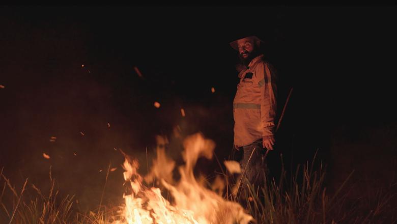 Man lighting bush fire (a still from Burnt Country film)