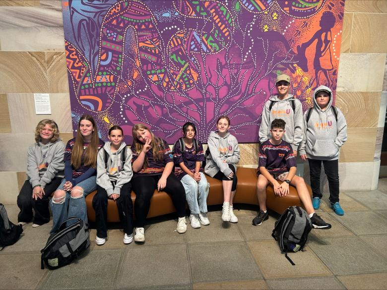 Group of all the year 7 and 8 students in front of RAP artwork 