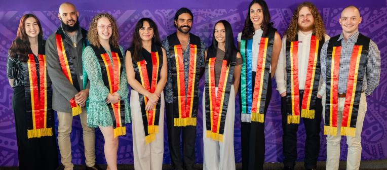Nine graduands pose with Aboriginal and Torres Strait Islander sashes