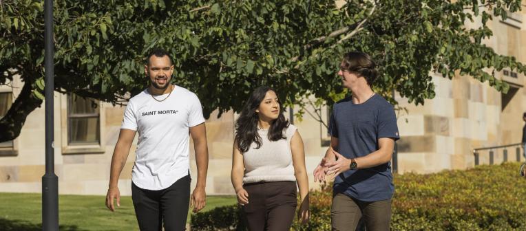 Elijah David walking with a group of students near Forgan Smith