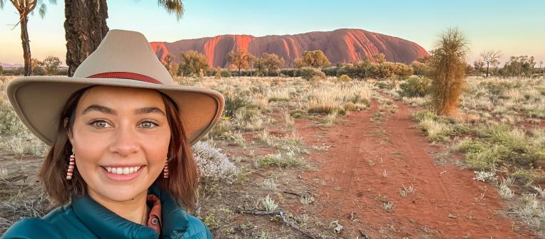 Young woman smiling in front of Uluru 