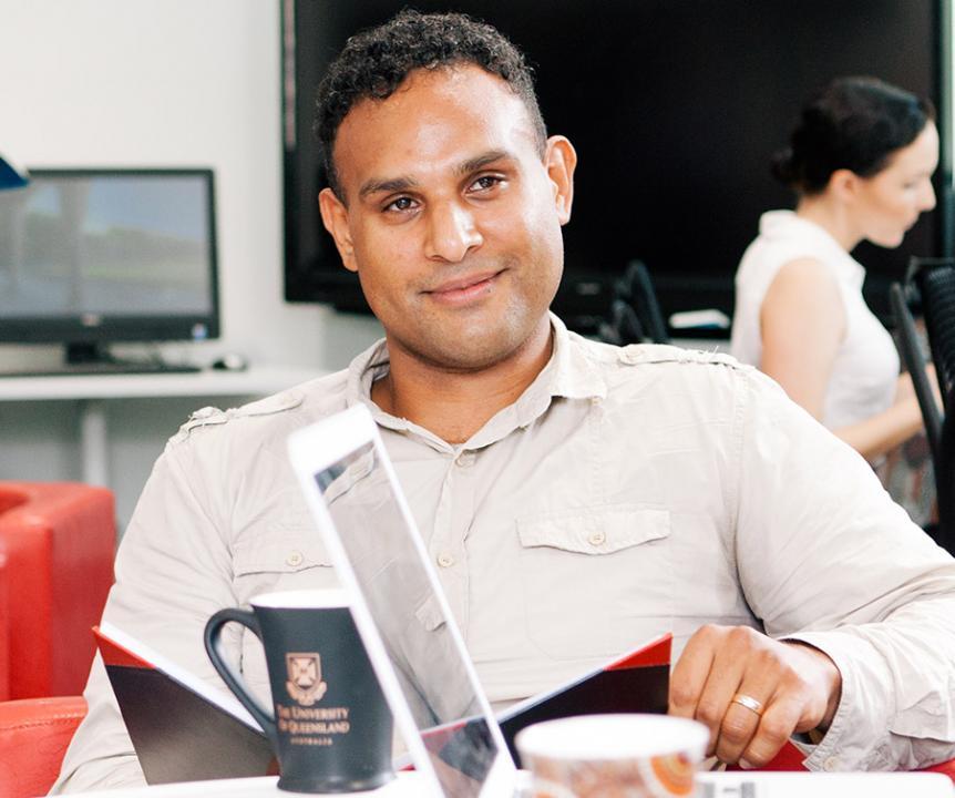 Male student smiling with notebook open.