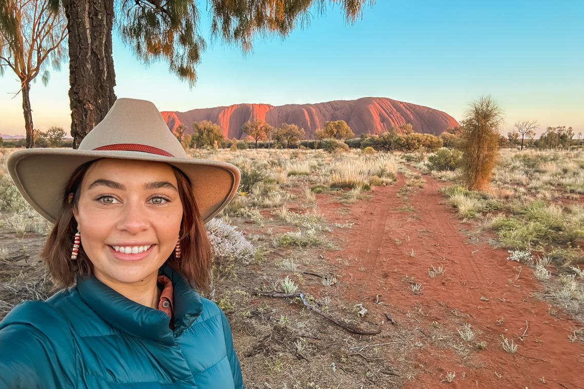 Young woman smiling in front of Uluru 